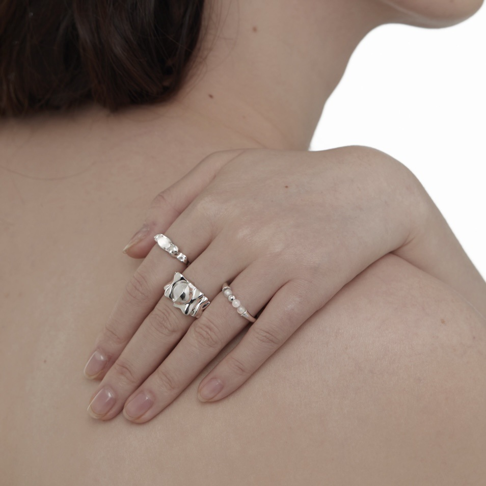 Folded silver-tone ring styled with other rings