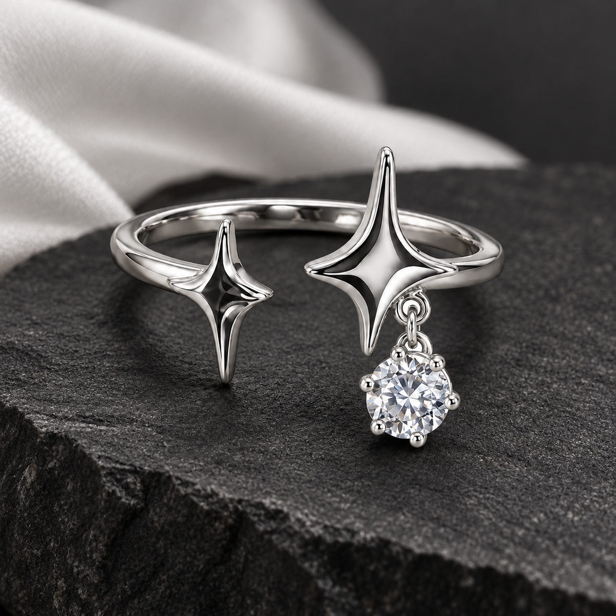Double star drop ring displayed on dark stone
