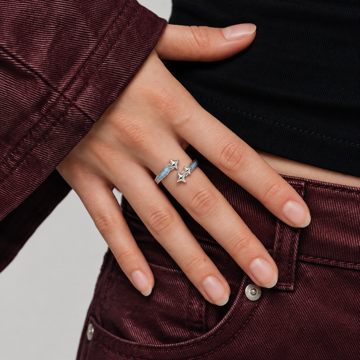 Blue star ring worn with burgundy denim