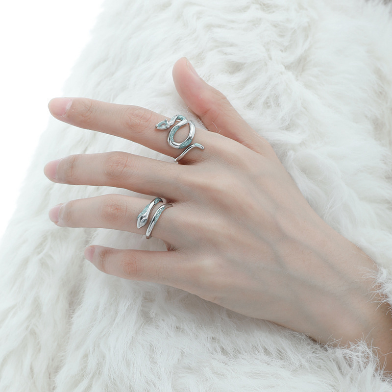 Close-up of both blue snake rings worn on a hand