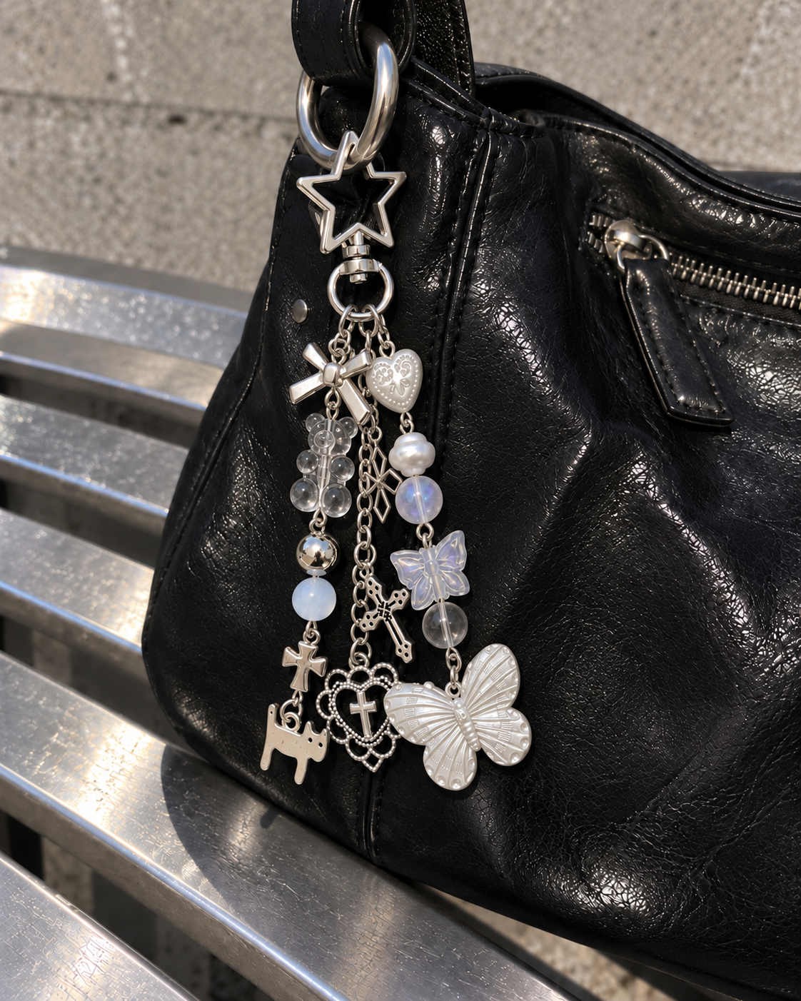 Butterfly charm keychain hanging from a black bag