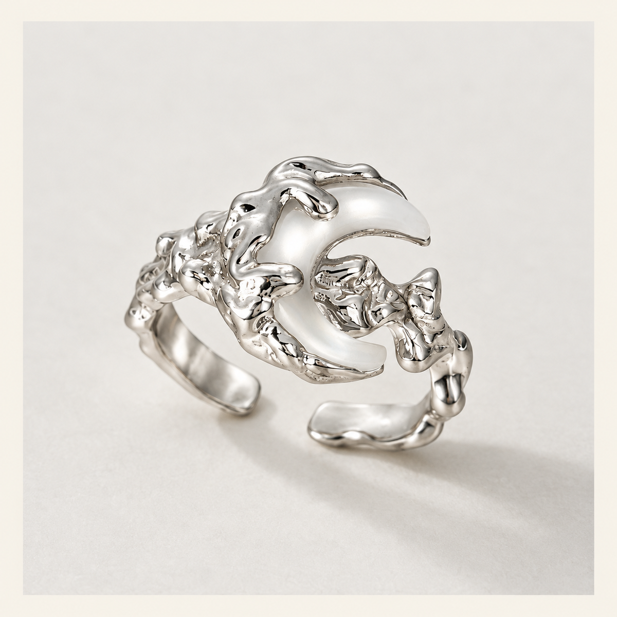 Silver-tone crescent moon open ring on a light background