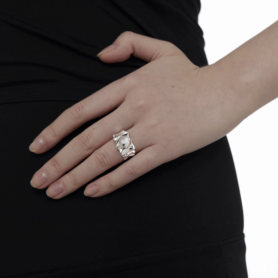 Folded silver-tone ring worn on hand