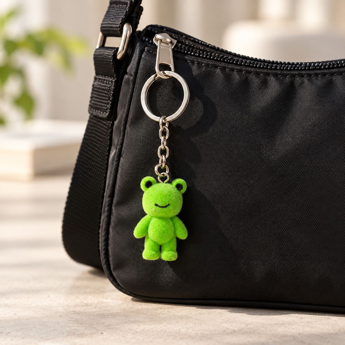 Green frog keyring on a black bag
