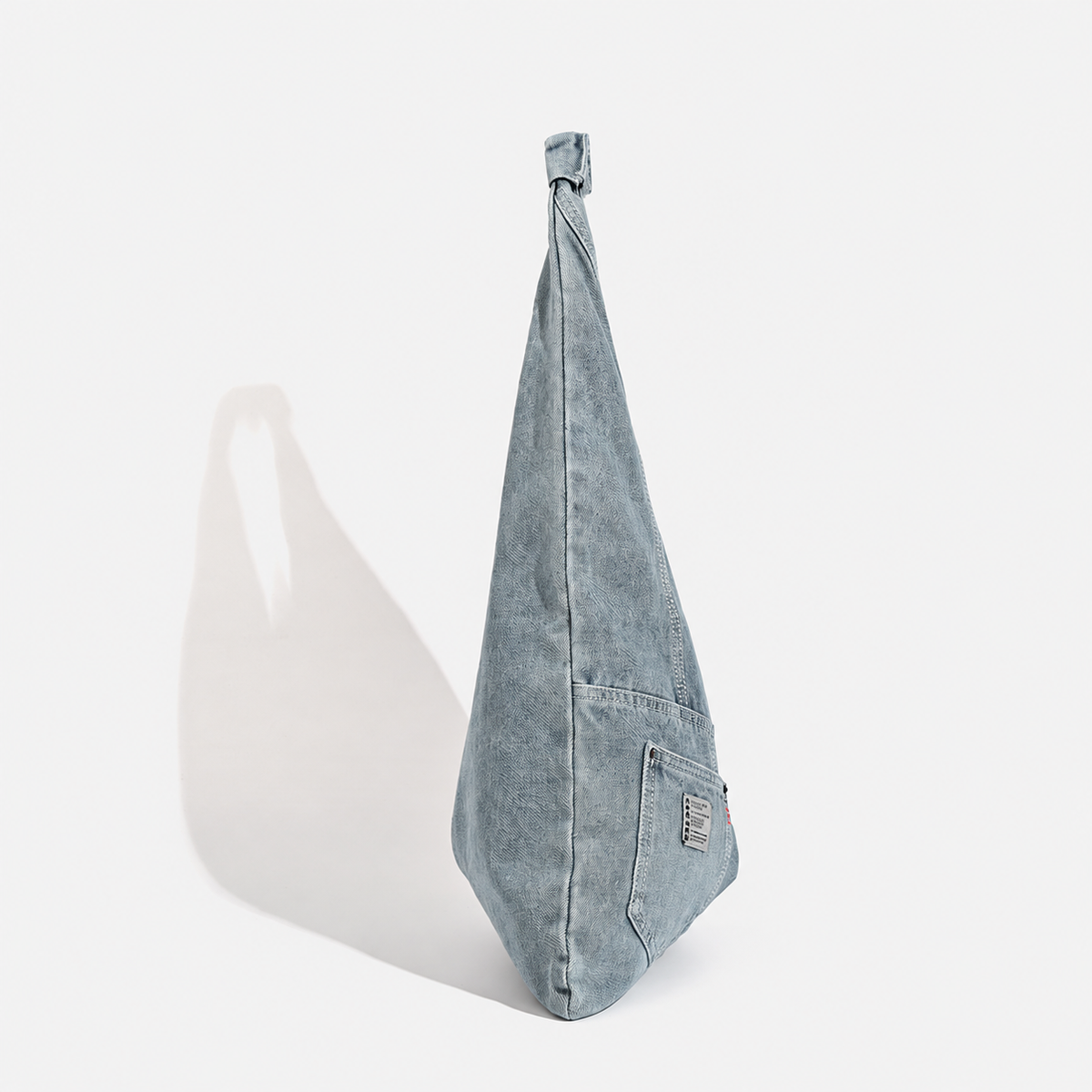 Denim triangle shoulder bag — light blue side