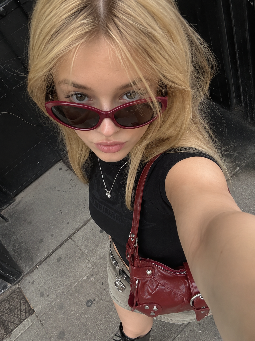 Burgundy bag and sunglasses street detail