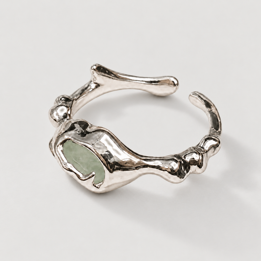 Organic silver-tone open ring with pale stone on ivory background
