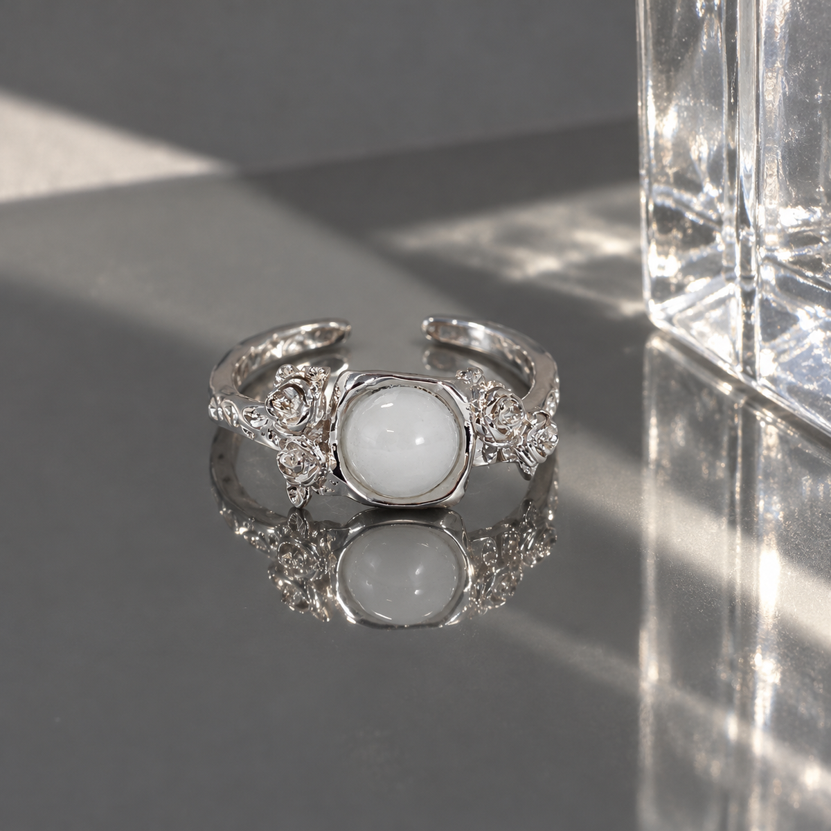 White stone rose open ring on reflective surface